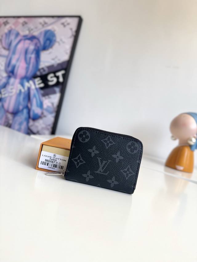 海外原单M60067黑花独家实拍！这款拉链零钱包为都市人提供了最理想的选择。包身精巧紧凑，可以用来装零钱、信用卡和折叠起来的纸币。即使身上的口袋小，也可轻松地将