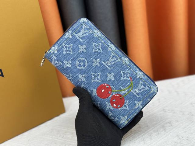 独家实拍 M23161 這款必備的拉鏈錢包以玩味風格重新演繹，以享負盛名的Louis Vuitton X Murakami第二版跨界聯乘系列設計登場。錢包以品牌