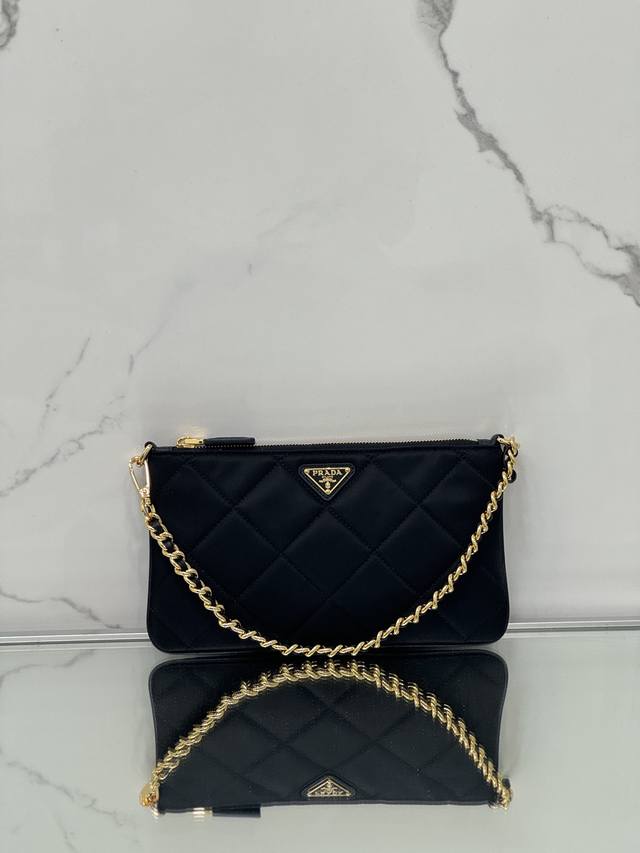 链条腋下包 这款手拿包选用再生尼龙 Re-Nylon 打造,体现了Prada标志性面料的可持续演变,采用简洁优雅的设计。展现品牌的二元性内核,巧妙融合现代实用的 链条腋下包 这款手拿包选用再生尼龙 Re-Nylon 打造,体现了Prada标志性面料的可持续演变,采用简洁优雅的设计。展现品牌的二元性内核,巧妙融合现代实用的