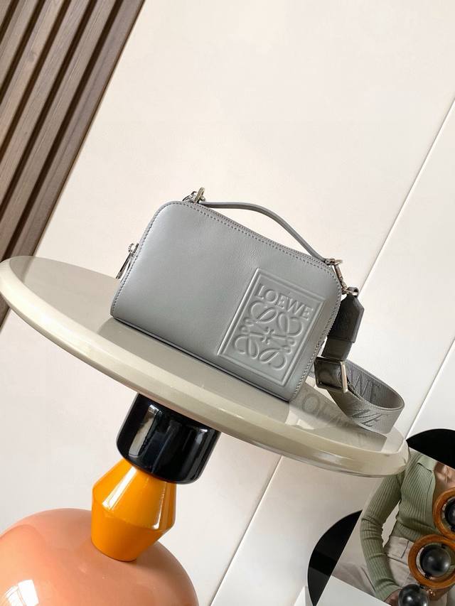 缎面牛皮革迷你相机斜挎包满足你的多功能需求，这款迷你相机包采用缎面牛皮革制成质感柔滑，展现出高级品质迷你相机斜挎包设计紧凑实用，设有两个拉链隔层，方便存放相机和