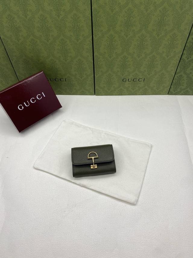 配红盒包装 Gucci延续品牌深厚传承，深化与马术本源的联结。半马衔扣图案化身为开合细节，为多款小皮件增色添彩。这款卡片夹以古驰棕色粒面牛皮革匠心打造，经典元素
