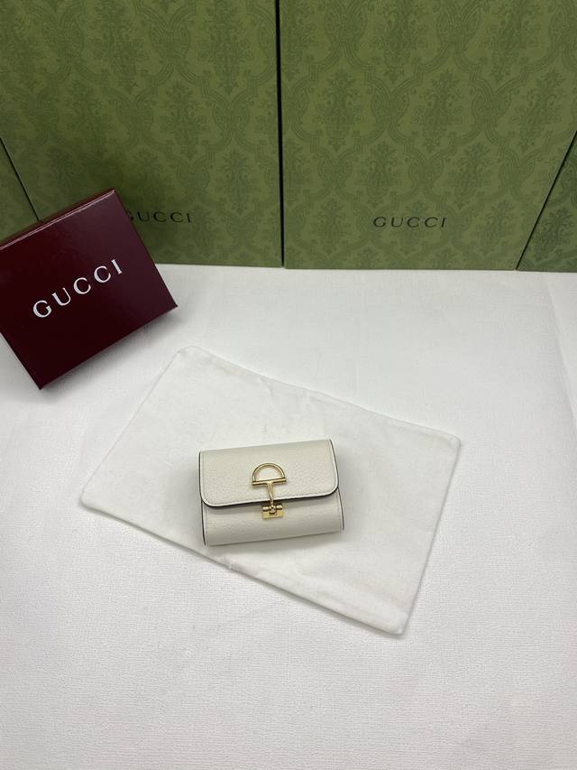 配红盒包装 Gucci延续品牌深厚传承，深化与马术本源的联结。半马衔扣图案化身为开合细节，为多款小皮件增色添彩。这款卡片夹以古驰棕色粒面牛皮革匠心打造，经典元素