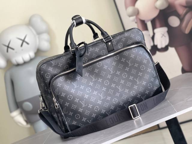 M11512 本款 Weekender手袋以Monogram Eclipse帆布塑造合宜尺寸，可通过背面饰带轻松固定于Horizon 拉杆箱顶部。俊朗设计囊括前