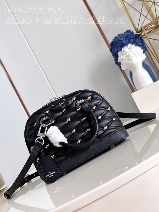 顶级原单 独家实拍 M23666黑打钉 本款 Alma Bb 手袋为菱纹羊皮革点缀莹亮菱形饰钉，巧妙致意品牌硬箱的绗缝内衬设计。辊压皮革手柄和可拆卸并调节的肩带