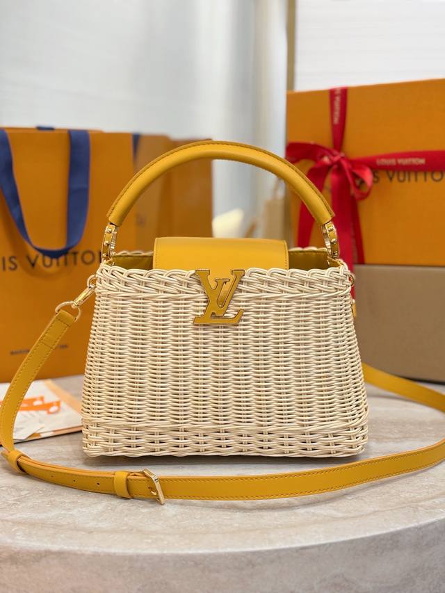 M24976小号黄色 本款 Capucines Bb 手袋以藤条编织别致构型，致意 1892 年问世的路易威登野餐箱设计。牛皮革塑造顶部手柄和翻盖，Lv 字母流