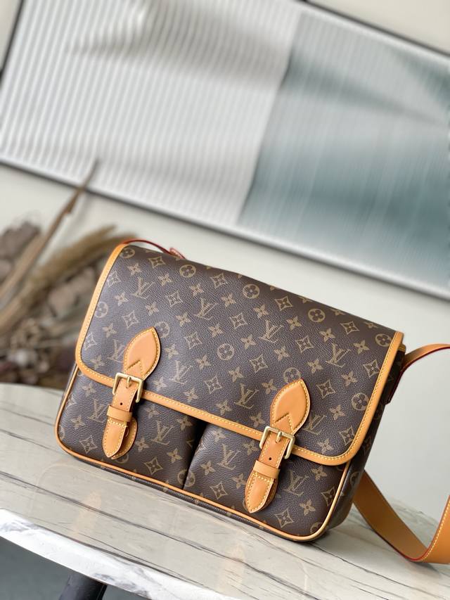 顶级原单 M14723 本款Satchel邮差包向1990年代的经典Gibeciere手袋汲取灵感，为Monogram帆布搭配牛皮革饰边。翻盖开合配有精巧搭扣，