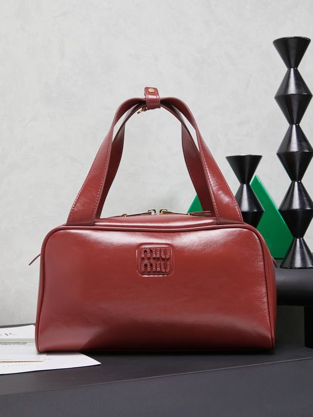 5Bb182，新品爆款腋下保龄球包，这款手提包的新演绎以平坦的手柄，正面优雅徽标以及柔软小牛皮的微妙光泽为特色，体现Miu M的精致实验精神，皮质柔软高级，风格