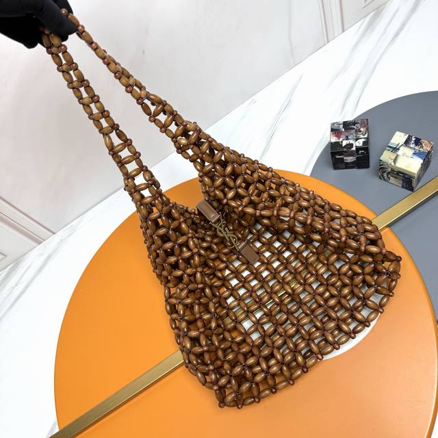 Le 5A7手工编织袋 这款木质编织包简直就是夏日宝藏！设计简约大方，手柄的编织工艺精致，很有质感。标志性的金属Logo钩扣点缀其中，奢华感与时尚感并存！ 搭配