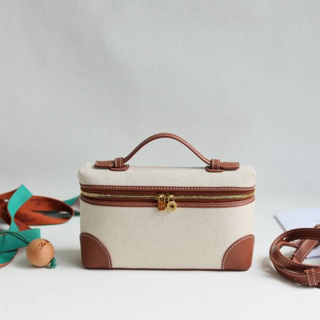 Loro Piana Extra Pocket L19手拿包 颜色：焦糖帆布角贴 宽开口小袋采用如黄油般柔软的小牛皮打造。随附可拆卸肩带，可打造出百搭迷你包袋。