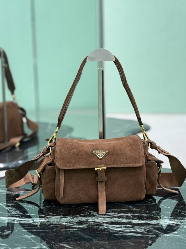 新款邮差包 肉桂色 小号 这款手袋完美融合精致与功能性，采用进口麂皮轮廓柔和，配有多个口袋。轻盈实用的设计结合运动与百搭元素，饰有涂珐琅三角形金属徽标，搭配皮革