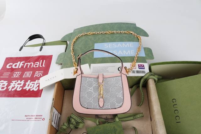 跑量价 简介： Aria-时尚咏叹调 Jackie 1961系列焕新推出质感柔软、结构灵活的长方形托特包。该系列标志性的金色调推入式锁扣配件。 闪耀的水钻配高贵