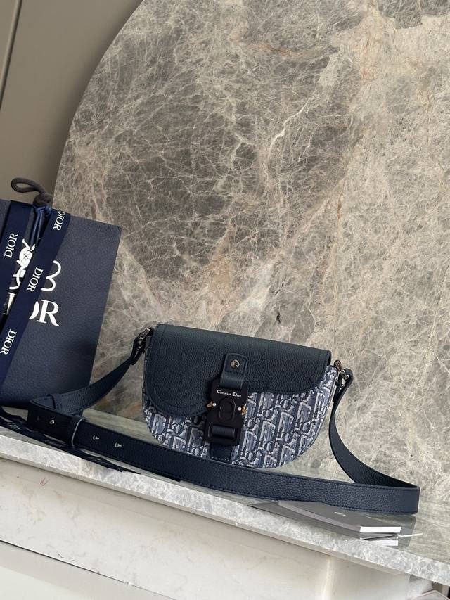 正品级 这款马鞍信使包突显时尚的设计，搭配翻盖，彰显精致的优雅气质，为马鞍系列提升格调。采用蓝色Oblique 印花面料等材质精心制作，搭配同色调粒面牛皮革马鞍