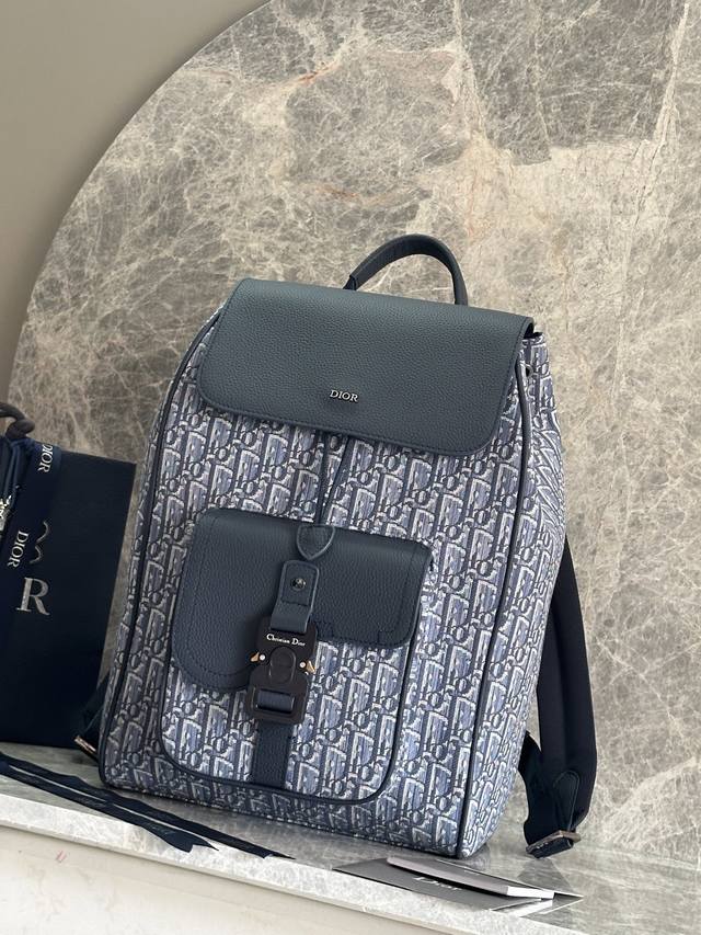 正品级 这款马鞍双肩背包是二零二五秋季男装系列新品，采用时尚的原创设计，突显马鞍风格。采用浅蓝布和蓝色Oblique 印花面料精心制作，饰以蓝色粒面牛皮革细节，