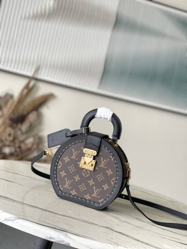 M15293 本款 Bote Chapeau 小号帽箱向品牌 19 世纪末的经典帽箱汲取灵感，以 Monogram 帆布塑造圆润廓形，搭配牛皮革饰边和铆钉装饰，