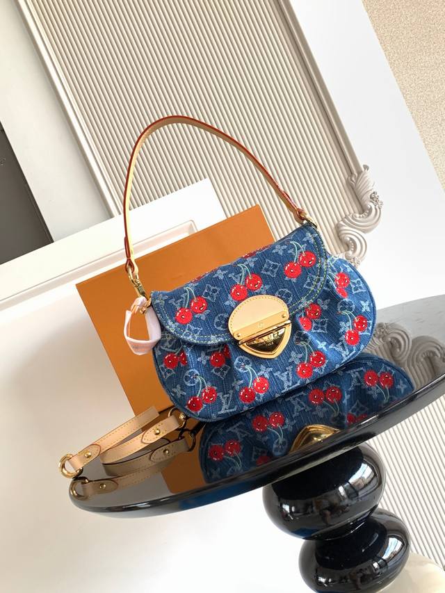 特级 动态芯片 本款 手袋取材 丹宁布，以复古笔触塑造圆润构型，再借醒目插扣点亮设计。明丽樱桃刺绣彰显路易威登 村上隆复刻系列的灵动格调，饰钉皮革肩带完善整体。