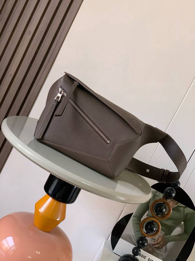 新款小号经典牛皮革 puzzle 腰包长方体形状和精确的切割技术创造了puzzle 独特的几何线条这款小号腰包采用经典牛皮革制成皮质柔软轻便，造型低调有辨识度不