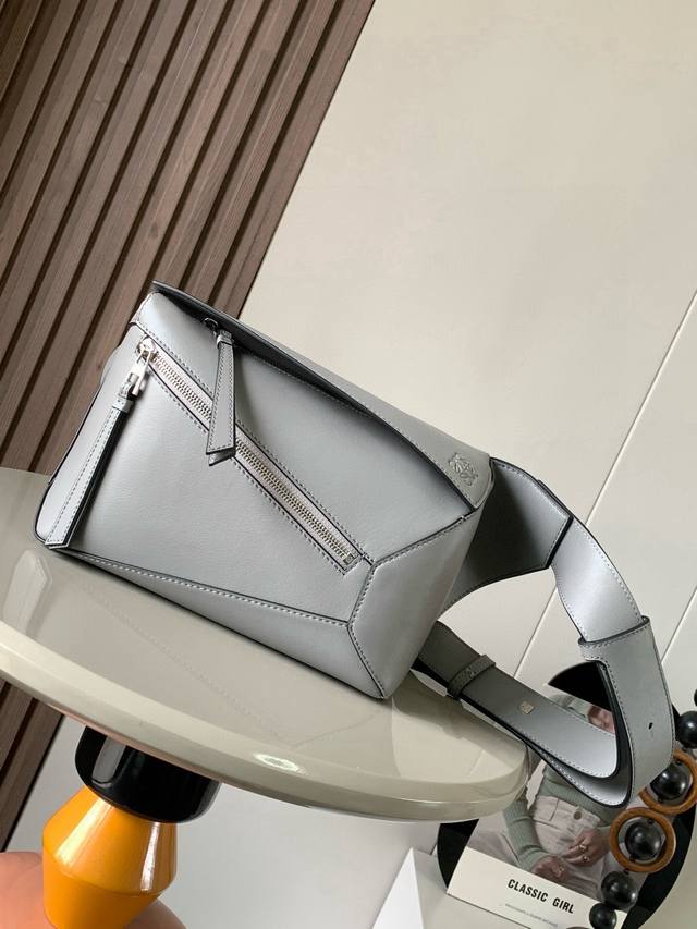 新款小号经典牛皮革 puzzle 腰包长方体形状和精确的切割技术创造了puzzle 独特的几何线条这款小号腰包采用经典牛皮革制成皮质柔软轻便，造型低调有辨识度不