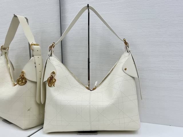 顶级原单这款 Dior Voyage 手袋是二零二六早春成衣系列新品，融合柔软线条和高雅的细节，打造协调的廓形。采用白色粒面牛皮革精心制作，饰以扁平超大藤格纹缉