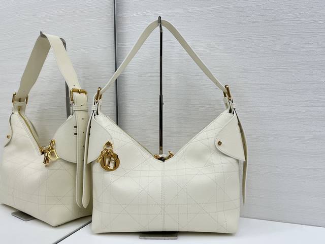 顶级原单这款 Dior Voyage 手袋是二零二六早春成衣系列新品，融合柔软线条和高雅的细节，打造协调的廓形。采用白色粒面牛皮革精心制作，饰以扁平超大藤格纹缉