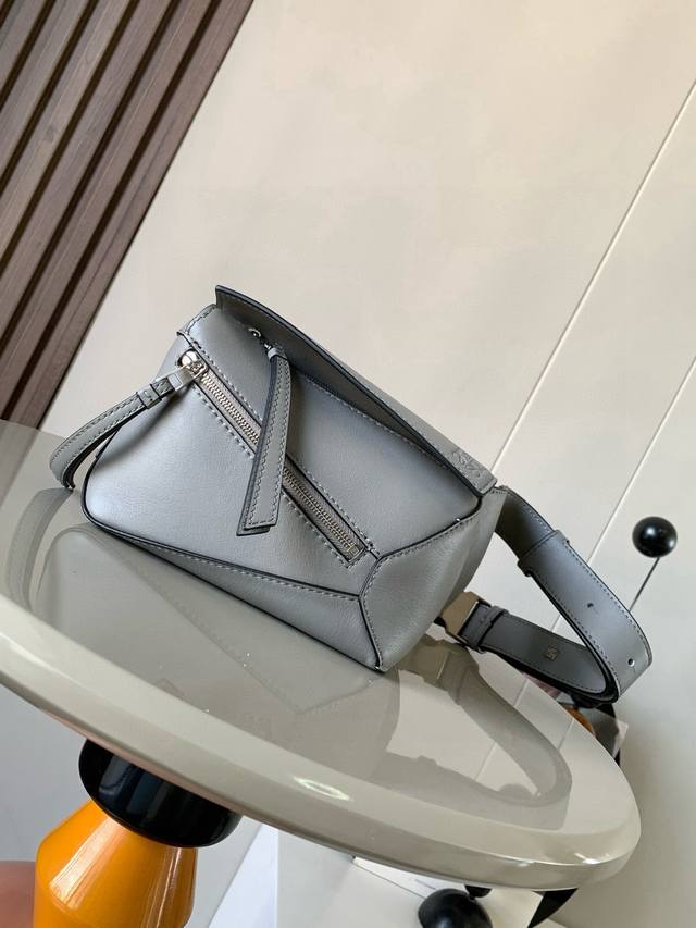 原厂皮 新款迷你号经典牛皮革 puzzle 腰包长方体形状和精确的切割技术创造了puzzle 独特的几何线条这款小迷你号腰包采用经典牛皮革制成皮质柔软轻便，造型