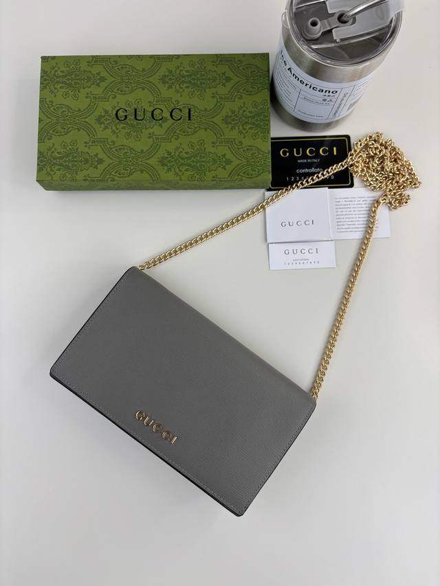 Guccl 饰手写体Gucci标识链带钱包。小号皮革配饰系列无缝融合现代时尚元素，塑就风格更迭但不失经典意蕴的匠心单品，为正装皮革单品汇入新鲜活力。这款链带钱包