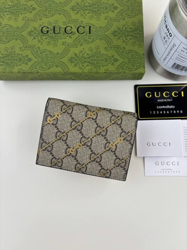Guccl 饰马衔扣印花长夹钱包。经典标识与别出心裁的廓形和细节交织融合，令典藏元素焕发出时尚现代魅力。这款短卡包以Gg Supreme帆布匠心打造，巧妙融入马