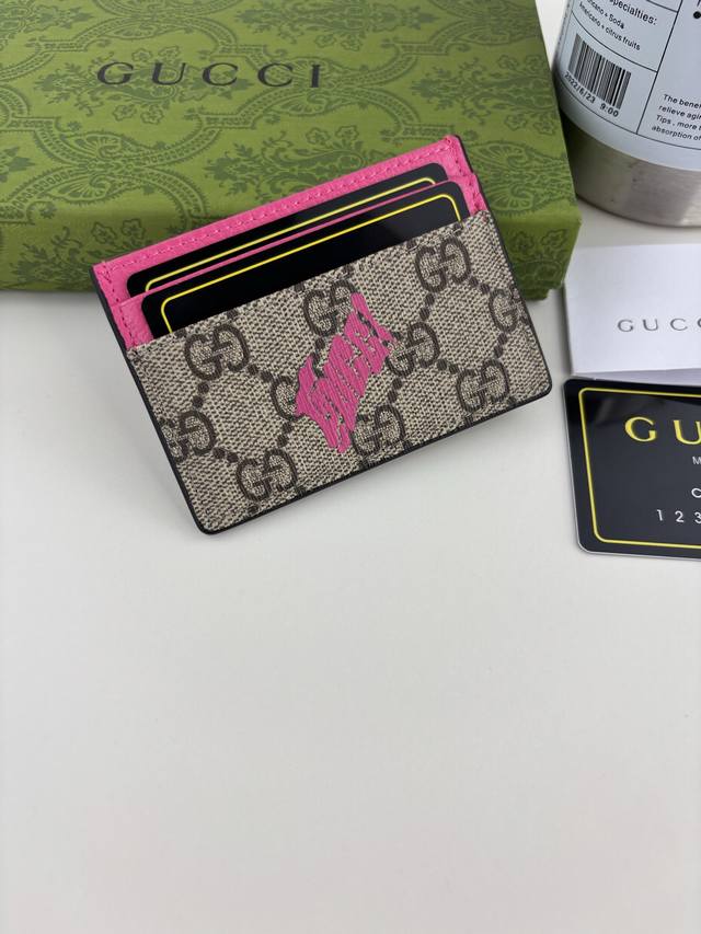 Guccl 这款双色卡片夹以经典Gg字母交织图案涂层织物匠心打造，巧妙融入Gucci印花和撞色皮革滚边，令整个设计愈发丰满。4个卡片隔层、1个开口口袋 款号: