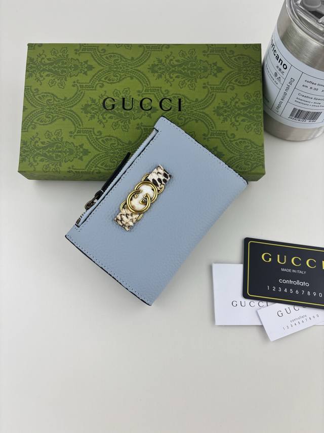 Guccl 夏季系列,全新推出这款钱包采用蓝色皮革精制而成,正面蝴蝶结以原色蟒蛇皮滚边和金色调互扣式双G细节打造而成 款号: 750459 尺寸: 12.5*9 Guccl 夏季系列,全新推出这款钱包采用蓝色皮革精制而成,正面蝴蝶结以原色蟒蛇皮滚边和金色调互扣式双G细节打造而成 款号: 750459 尺寸: 12.5*9