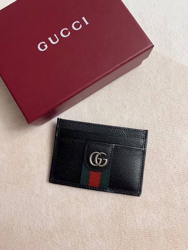 顶配版 新品 Ophidia系列革新蕴聚黑色配色与精致皮革，以全新功能弘彰品牌标志性廓形。这款卡片夹以自然光泽软皮打造，匠心缀饰双G标识和织带细节。 自然光泽黑