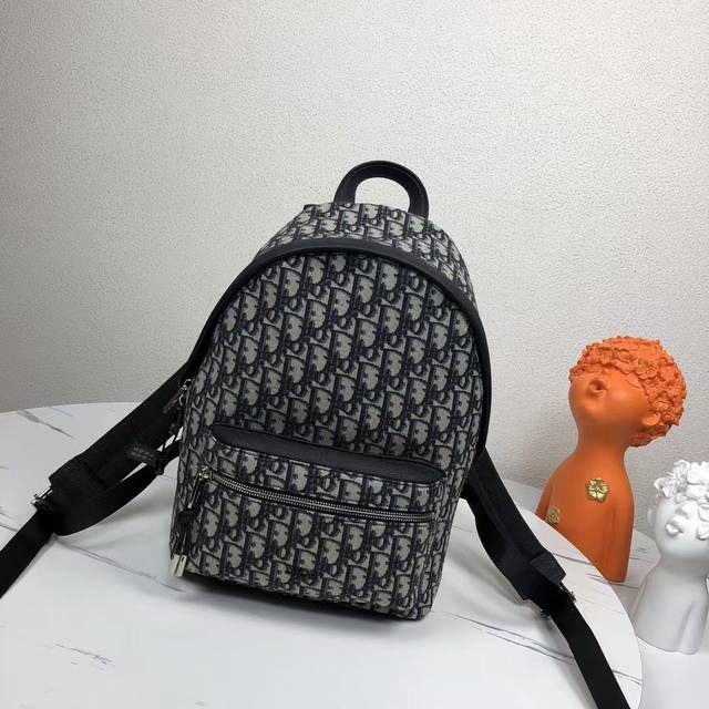 市场最高版本，欢迎对比 这款Rider双肩背包轮廓简约，经典的学院款式洋溢着活力。从Dior男装系列汲取灵感，采用米色和黑色提花面料重新诠释，通体饰以Obliq