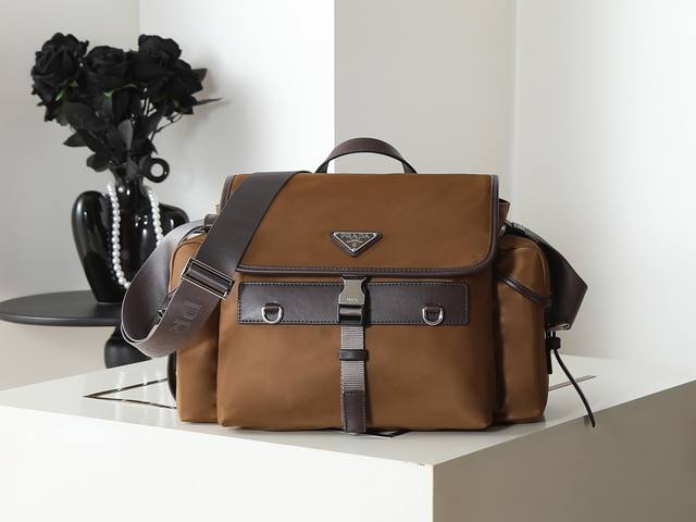 新品邮包2Vd081 这款Explore手袋完美融合了高雅与功能性，拥有多口袋的柔和线条轮廓。翻盖设计，专为城市探索和户外冒险而设计，配有肩带和提手柄，可多种方