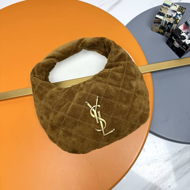 磨砂棕 金 Icare Baby麂皮手袋 备受瞩目的可颂形状包包闪亮登场，标志性的金属Logo点缀其中，完美结合复古与现代感，堪称本季最令人期待的It Bag之