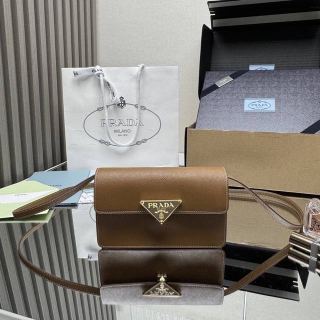 顶级原单 新品手袋1Bd386Mini款这款迷你手袋采用Saffano牛皮革打造。结构化的轮廓配有内部口袋和卡槽，并以金属标志性的三角形装饰闭合处。配有一条可调