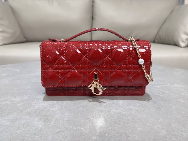 0980羊皮漆皮樱桃红 Lady Dior 珍珠手拿包 这款手拿包是本季新品，顶部搭配手柄，优雅实用，令 Lady Dior 系列更加丰富。采用羊皮皮革精心制作