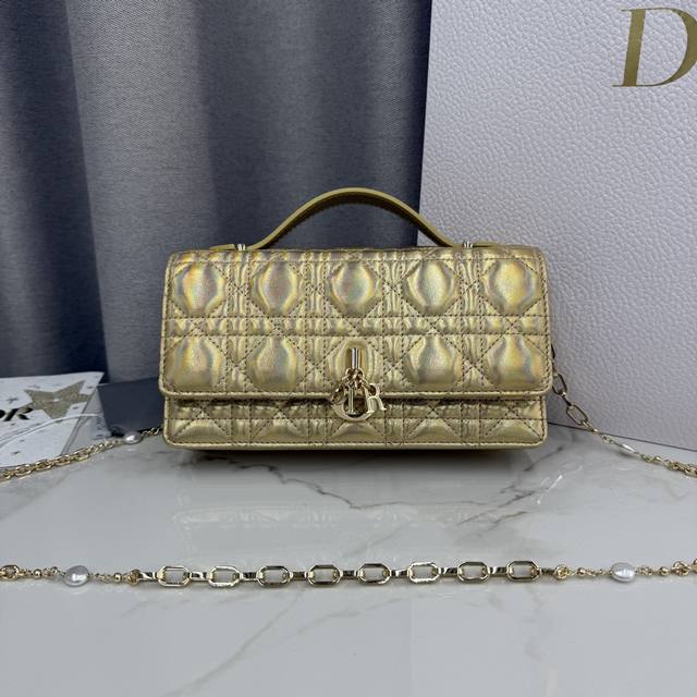 0980羊皮金色 Lady Dior 珍珠手拿包 这款手拿包是本季新品，顶部搭配手柄，优雅实用，令 Lady Dior 系列更加丰富。采用羊皮皮革精心制作，饰以