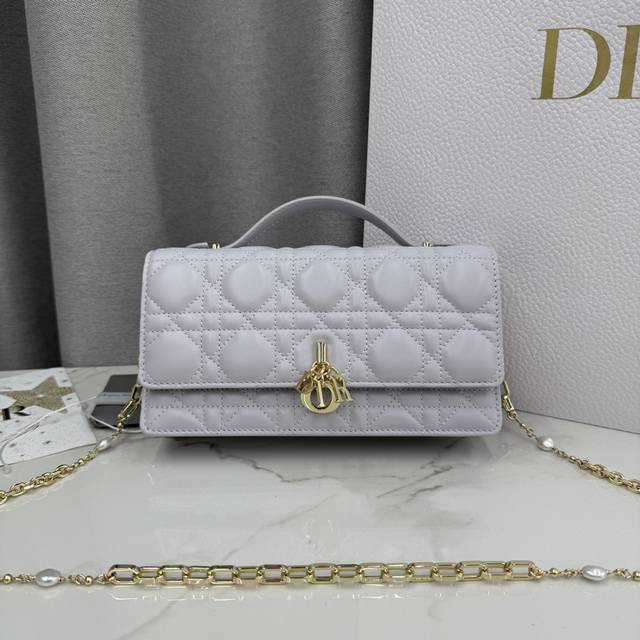 0980羊皮梦幻紫 Lady Dior 珍珠手拿包 这款手拿包是本季新品,顶部搭配手柄,优雅实用,令 Lady Dior 系列更加丰富。采用羊皮皮革精心制作,饰 0980羊皮梦幻紫 Lady Dior 珍珠手拿包 这款手拿包是本季新品,顶部搭配手柄,优雅实用,令 Lady Dior 系列更加丰富。采用羊皮皮革精心制作,饰