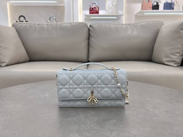 0980羊皮湖水蓝 Lady Dior 珍珠手拿包 这款手拿包是本季新品，顶部搭配手柄，优雅实用，令 Lady Dior 系列更加丰富。采用羊皮皮革精心制作，饰