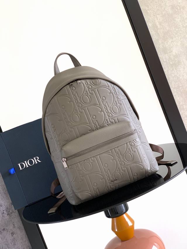这款 Rider 2.0 拉链双肩背包为 Dior 的经典单品推出全新版本。Dior Gravity 印花效果皮革采用压花工艺将经典图案精致地呈现于灰色牛皮革之