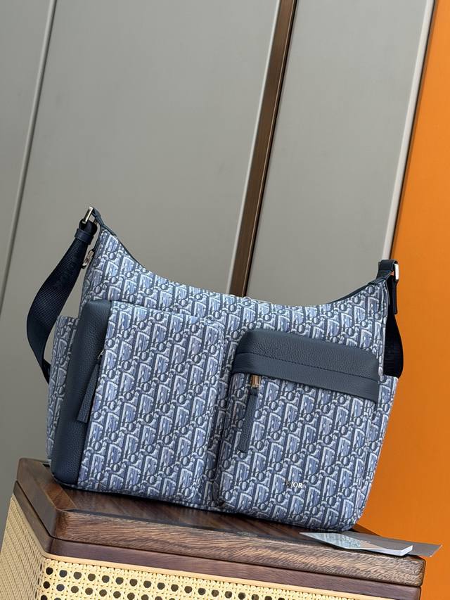 正品级 这款Rider Soft水饺包是二零二五秋季男装系列新品，兼具实用功能与时尚设计。采用蓝色Oblique 印花面料等材质精心制作，饰以同色调粒面牛皮革细