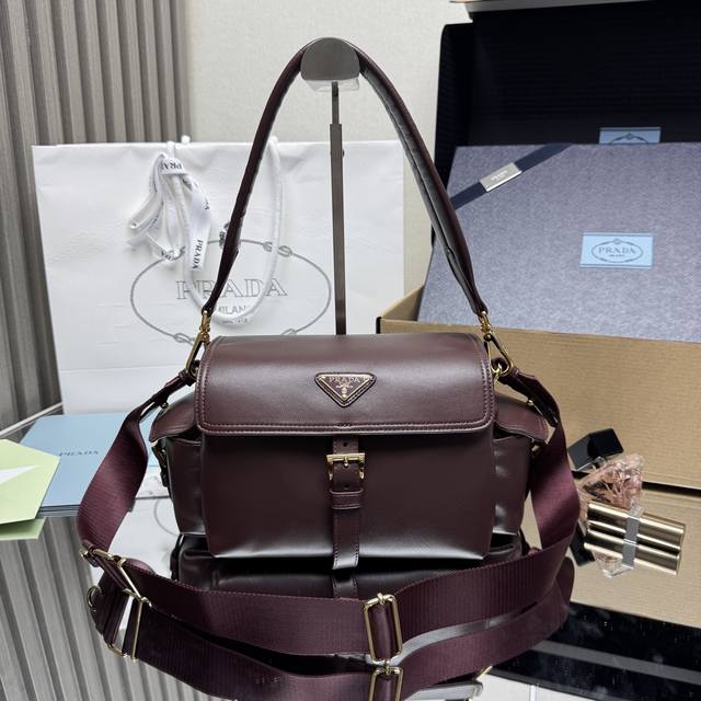 顶级原单 新款邮差包1Bd394羊皮 酒红色 到货 这款手袋完美融合精致与功能性，采用进口小羊皮。轮廓柔和，配有多个口袋。轻盈实用的设计结合运动与百搭元素，饰有