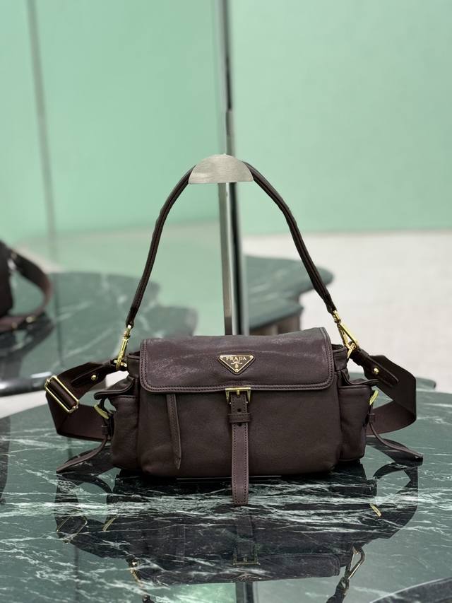 羊皮邮差包 这款手袋完美融合精致与功能性，采用进口小羊皮。轮廓柔和，配有多个口袋。轻盈实用的设计结合运动与百搭元素，饰有涂珐琅三角形金属徽标，搭配皮革细节。配有