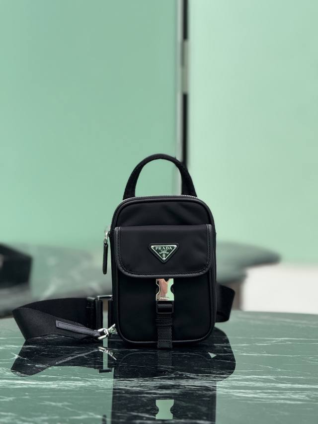 新品手机胸包 这款智能手机壳采用百搭现代设计，饰有三角形徽标，让再生尼龙邂逅Saffiano皮革材质，又可手提，前幅插扣口袋设计。 尺寸：长11.5X高17X衣