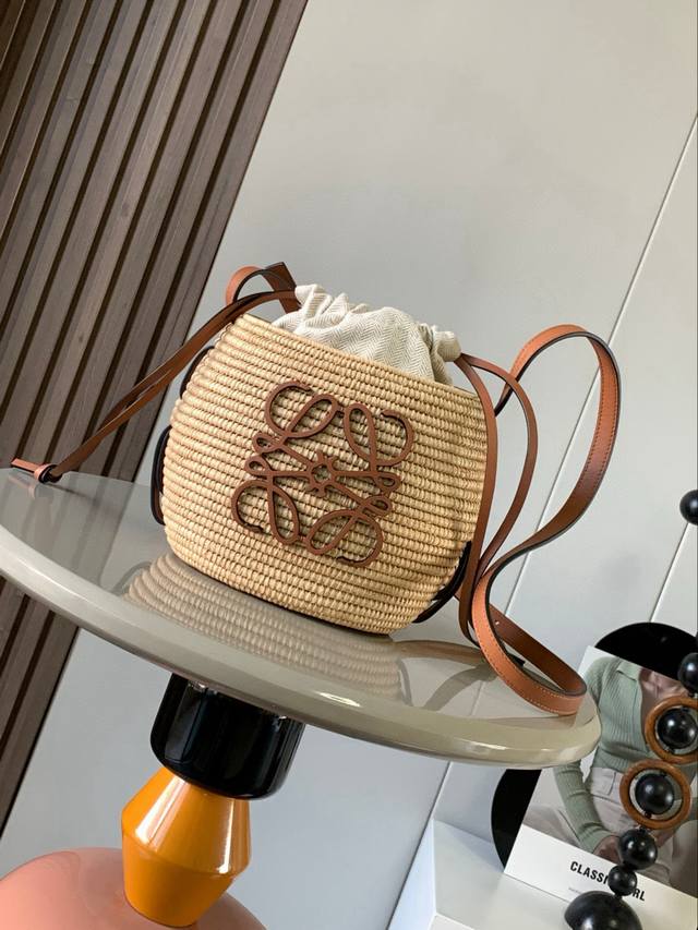 酒椰纤维和牛皮革蜂巢Basket小蜂巢／灯笼包手袋编织包配有穿过整个蜂巢形状包身的牛皮革肩带这个版本采用酒椰叶纤维和牛皮革制成配有内置抽绳小包，正面饰有牛皮革