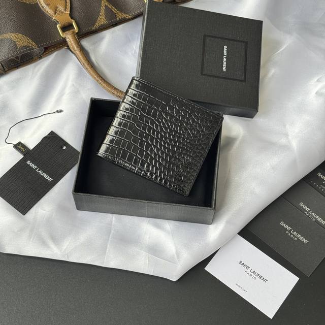 正品级 Ysl 男士钱包 黑色鳄鱼纹 内里可放卡片 大钞 牛皮制作 Monogram对折钱包,饰以金属Ysl字母标志。内部:两个纸币隔层、八个卡片槽和两个票据隔 正品级 Ysl 男士钱包 黑色鳄鱼纹 内里可放卡片 大钞 牛皮制作 Monogram对折钱包,饰以金属Ysl字母标志。内部:两个纸币隔层、八个卡片槽和两个票据隔