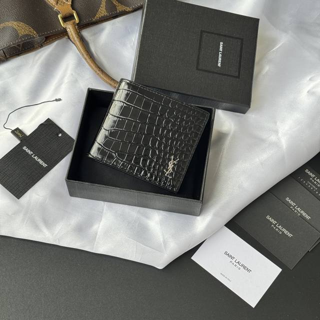 正品级 Ysl 男士钱包 黑色鳄鱼纹 内里可放卡片 大钞 牛皮制作 Monogram对折钱包，饰以金属Ysl字母标志。内部：两个纸币隔层、八个卡片槽和两个票据隔