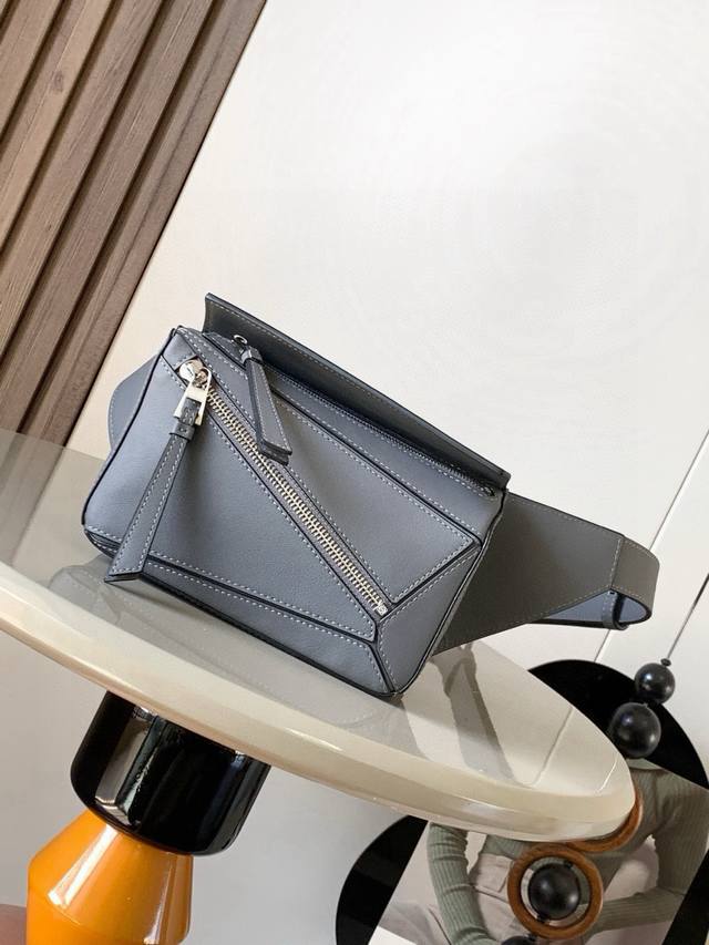 迷你号经典牛皮革 Puzzle 腰包长方体形状和精确的切割技术创造了Puzzle 独特的几何线条这款小迷你号腰包采用经典牛皮革制成皮质柔软轻便，造型低调有辨识度