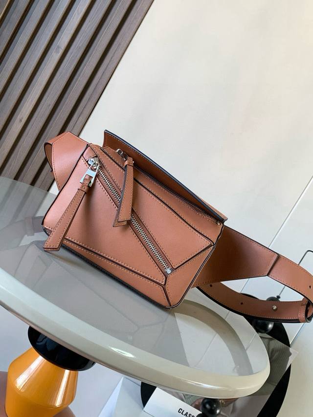 迷你号经典牛皮革 Puzzle 腰包长方体形状和精确的切割技术创造了Puzzle 独特的几何线条这款小迷你号腰包采用经典牛皮革制成皮质柔软轻便，造型低调有辨识度