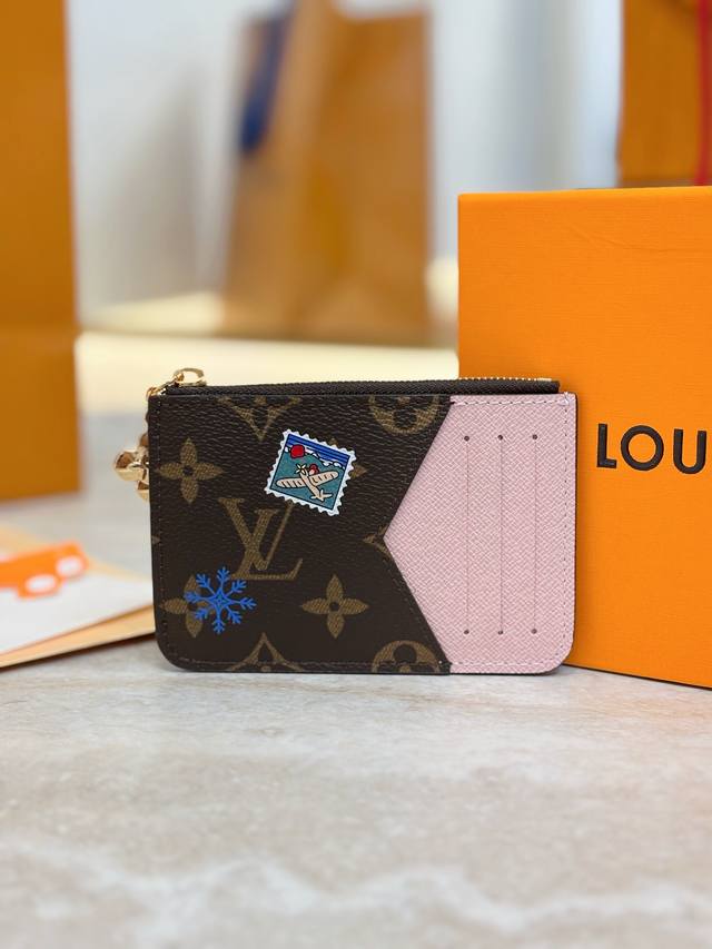 M15333 圣诞款 Romy 卡夹、本款 Romy 卡夹演绎 Vivenne Wintery Travel 系列的玩趣新姿。Monogram 帆布搭配皮革内衬