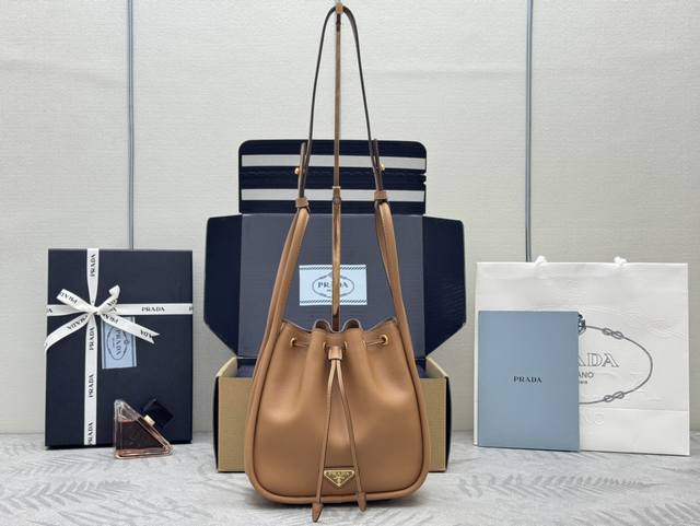 新款水桶包1Be087焦糖 这款水桶包采用进小牛皮，配有一条可拆卸长肩带，多种背法。又可手提又可肩带，袋口为抽绳设计，功能性強，太完美空间大，上身效果好看又时尚