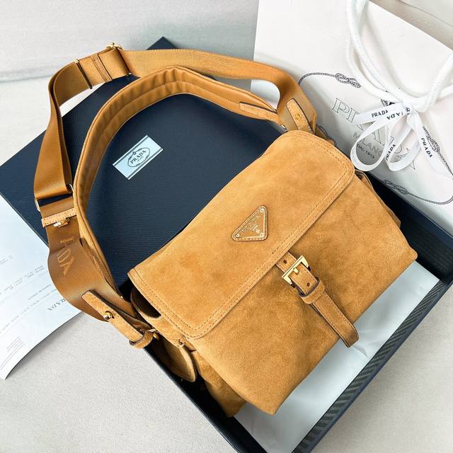 新款邮差包1Bd394麂皮 这款手袋完美融合精致与功能性，采用进口麂皮轮廓柔和，配有多个口袋。轻盈实用的设计结合运动与百搭元素，饰有涂珐琅三角形金属徽标，搭配皮